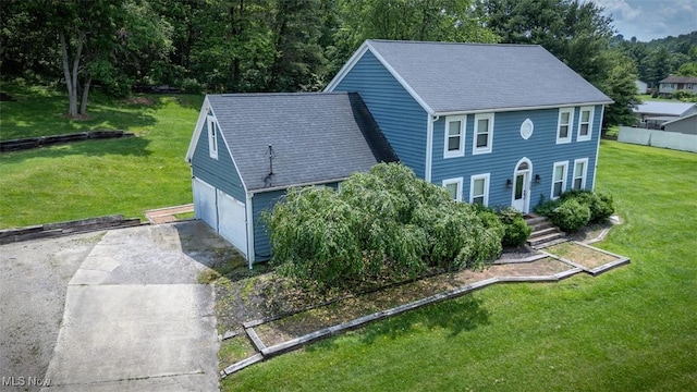 1310 Oxbow Rd, Belpre, OH 45714 - view of front facade with driveway, a garage, a shingled roof, and a front yard