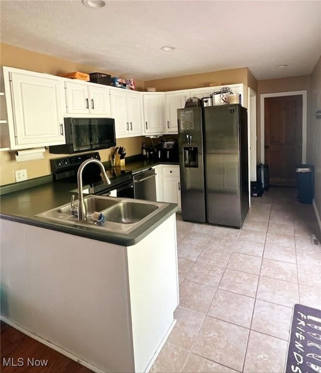 1310 Oxbow Rd, Belpre, OH 45714 - kitchen featuring fridge with ice dispenser, black microwave, stainless steel dishwasher, dark countertops, and a peninsula