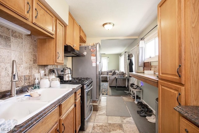 35109 Elm Rd, Grafton, OH 44044 - kitchen featuring stainless steel gas range oven, under cabinet range hood, backsplash, open floor plan, and brown cabinetry