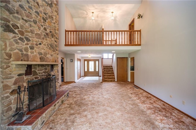 3355 Waterford Rd, New Waterford, OH 44445 - unfurnished living room with a high ceiling, carpet, stairway, and a stone fireplace