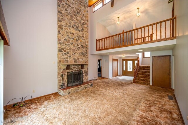3355 Waterford Rd, New Waterford, OH 44445 - unfurnished living room with a towering ceiling, carpet, stairway, and a fireplace