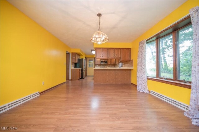 3355 Waterford Rd, New Waterford, OH 44445 - kitchen with stainless steel appliances, a baseboard radiator, a chandelier, a peninsula, and light wood finished floors