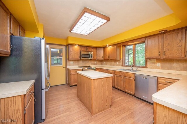 3355 Waterford Rd, New Waterford, OH 44445 - kitchen featuring stainless steel appliances, tasteful backsplash, light wood-style floors, light countertops, and a kitchen island