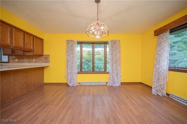 3355 Waterford Rd, New Waterford, OH 44445 - unfurnished dining area featuring a chandelier, light wood-style flooring, and a baseboard radiator