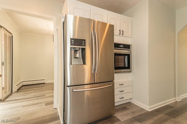 3 Meadowlawn Dr Unit 13, Mentor, OH 44060 - kitchen featuring appliances with stainless steel finishes, a baseboard heating unit, wood finished floors, and white cabinets