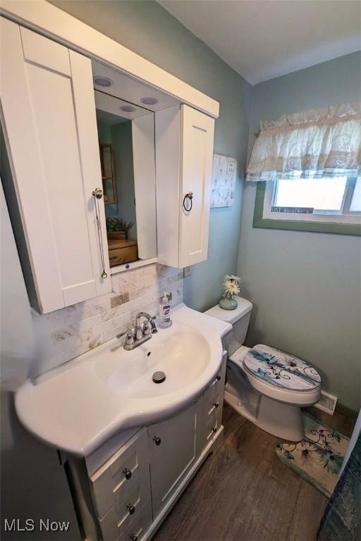 6323 Olive Ave, North Ridgeville, OH 44039 - bathroom with vanity, tasteful backsplash, and wood finished floors