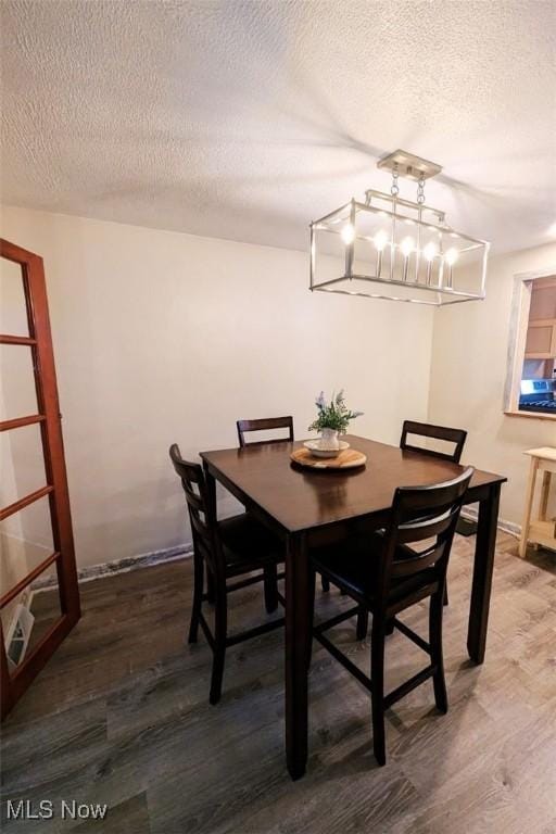 6323 Olive Ave, North Ridgeville, OH 44039 - dining space featuring wood finished floors, a textured ceiling, and a chandelier