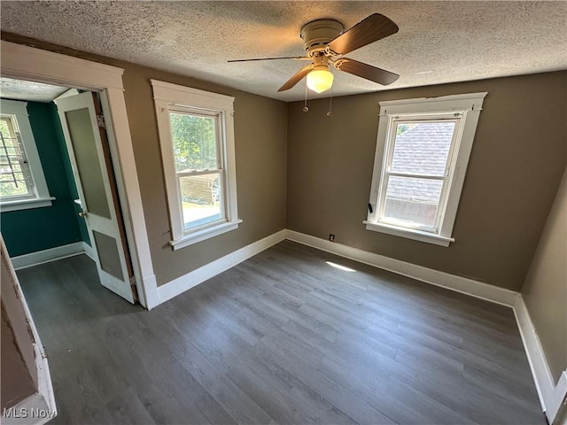 841 Kling St, Akron, OH 44311 - unfurnished room featuring a textured ceiling, healthy amount of natural light, dark wood-style floors, and ceiling fan