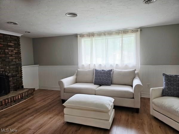 7957 Pamela Dr, North Royalton, OH 44133 - living room featuring a wainscoted wall, wood finished floors, and a brick fireplace