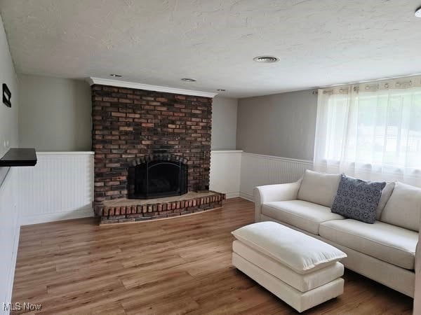 7957 Pamela Dr, North Royalton, OH 44133 - living room featuring wainscoting, wood finished floors, and a brick fireplace