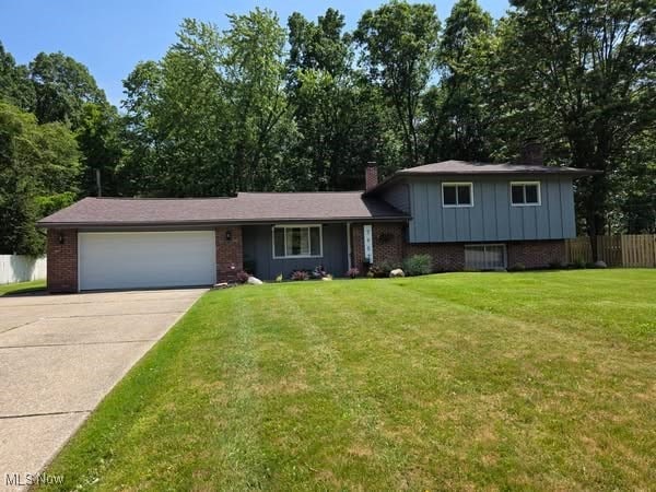 7957 Pamela Dr, North Royalton, OH 44133 - tri-level home featuring brick siding, a garage, driveway, and a chimney