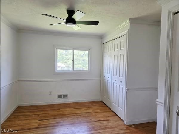 7957 Pamela Dr, North Royalton, OH 44133 - unfurnished bedroom with ornamental molding, light wood finished floors, a closet, and a ceiling fan
