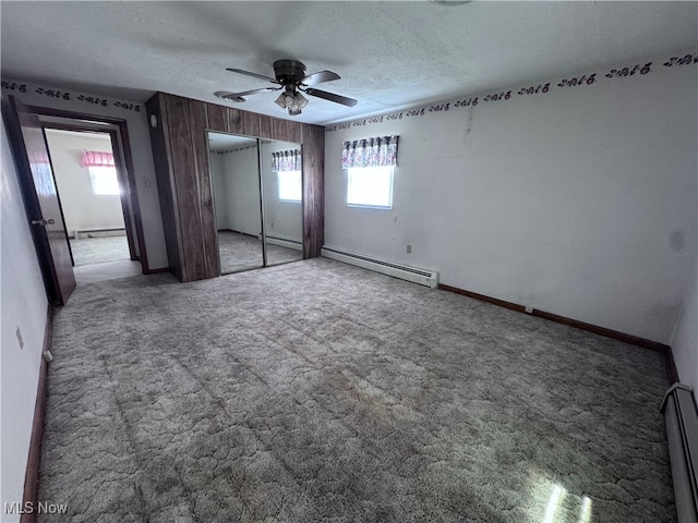 1605 Gihon Rd, Parkersburg, WV 26101 - unfurnished bedroom featuring a baseboard heating unit, multiple windows, carpet floors, and a textured ceiling