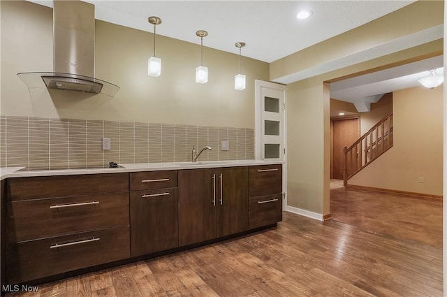 1549 Galaxy Dr, Mogadore, OH 44260 - kitchen featuring ventilation hood, light countertops, dark wood-style floors, backsplash, and dark brown cabinetry