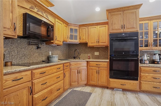 1549 Galaxy Dr, Mogadore, OH 44260 - kitchen with black appliances, decorative backsplash, light stone counters, and glass insert cabinets
