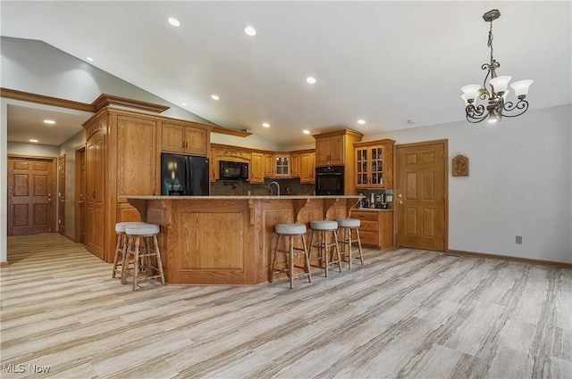 1549 Galaxy Dr, Mogadore, OH 44260 - kitchen with black appliances, brown cabinets, lofted ceiling, a breakfast bar, and backsplash