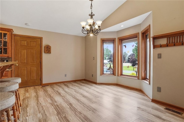 1549 Galaxy Dr, Mogadore, OH 44260 - unfurnished dining area featuring light wood-style flooring, a chandelier, and lofted ceiling