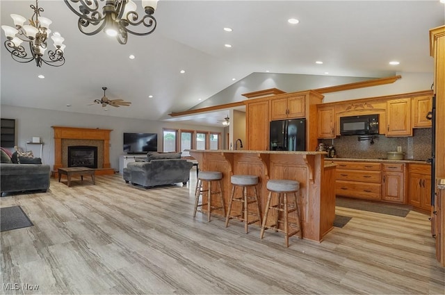 1549 Galaxy Dr, Mogadore, OH 44260 - kitchen featuring black appliances, a ceiling fan, lofted ceiling, open floor plan, and a breakfast bar
