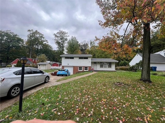 28842 Oring Rd, North Olmsted, OH 44070 - split level home featuring driveway, a front lawn, a garage, and view of wooded area