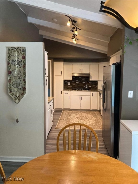 28842 Oring Rd, North Olmsted, OH 44070 - kitchen featuring freestanding refrigerator, under cabinet range hood, white cabinetry, beam ceiling, and tasteful backsplash