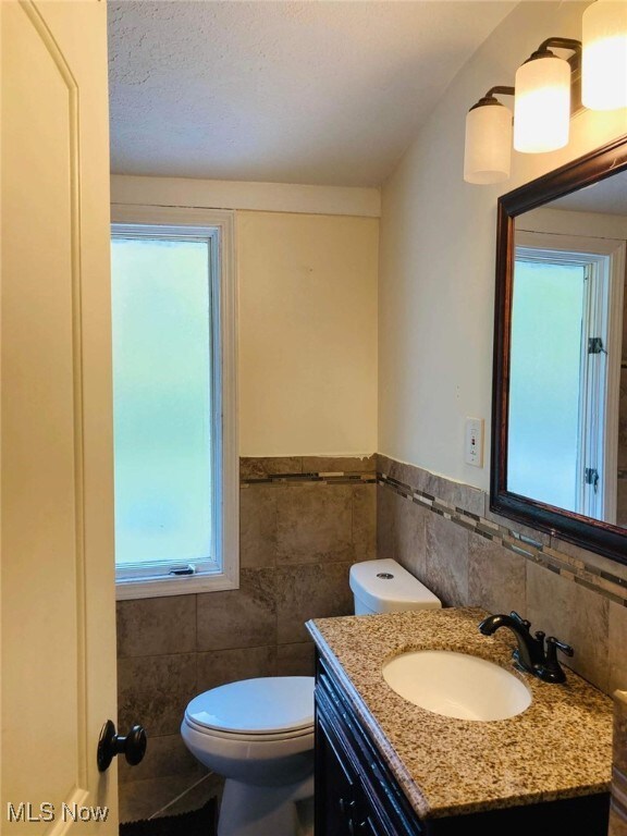 28842 Oring Rd, North Olmsted, OH 44070 - bathroom with tile walls, vanity, and wainscoting
