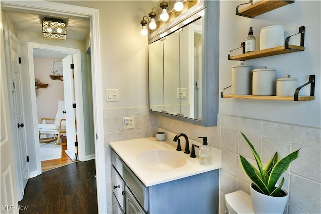 437 Hazel St, Girard, OH 44420 - bathroom featuring tile walls, vanity, wood finished floors, and a wainscoted wall