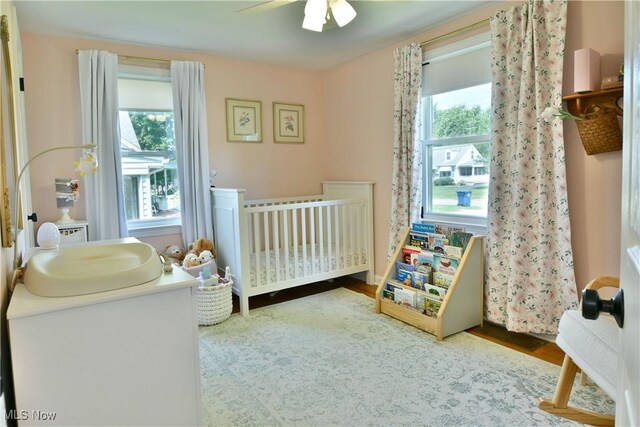 437 Hazel St, Girard, OH 44420 - bedroom featuring a nursery area, wood finished floors, and a ceiling fan