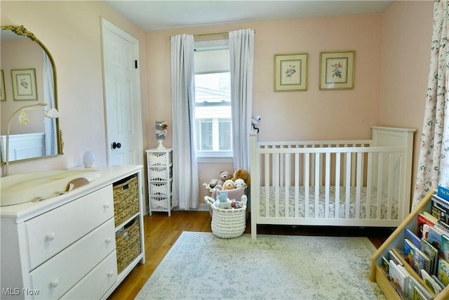 437 Hazel St, Girard, OH 44420 - bedroom featuring wood finished floors and a crib
