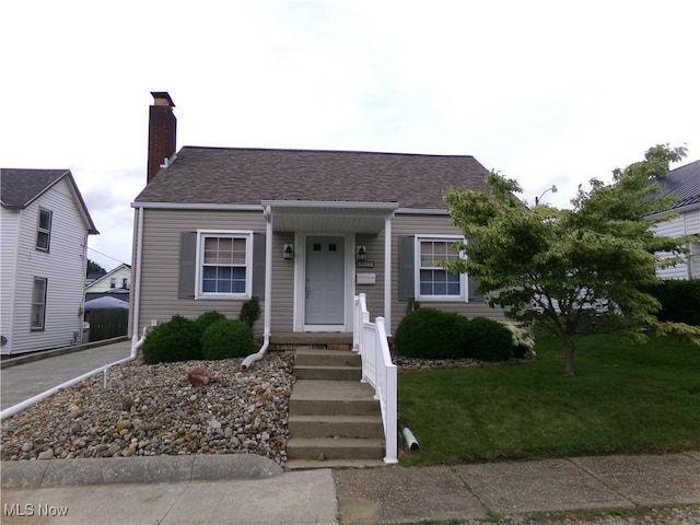 1612 Orange St, Coshocton, OH 43812 - view of front of home featuring a shingled roof and a chimney