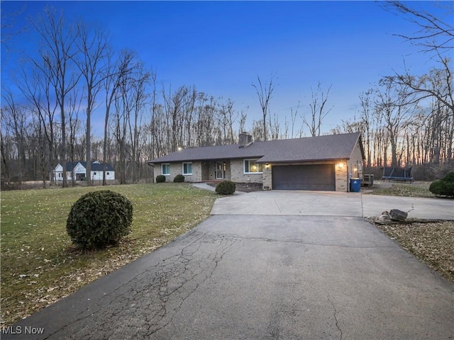 4234 Lyntz Townline Rd SW, Warren, OH 44481 - ranch-style home featuring a garage, driveway, a front lawn, a trampoline, and brick siding