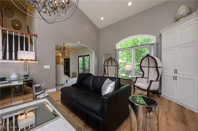 3595 Vineyard Ave NW, Canton, OH 44708 - living room with a chandelier, wood finished floors, high vaulted ceiling, arched walkways, and recessed lighting