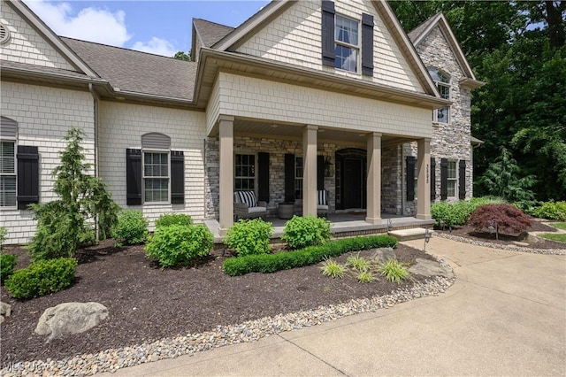 3595 Vineyard Ave NW, Canton, OH 44708 - view of exterior entry with covered porch, roof with shingles, and stone siding
