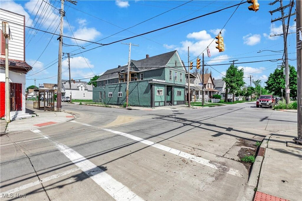 3356 W 44th St, Cleveland, OH 44109 - view of asphalt road featuring a residential view, sidewalks, curbs, traffic lights, and street lights