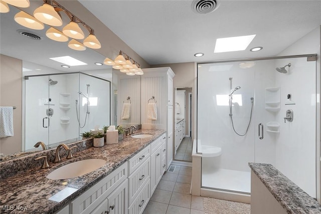4613 Compass Rose Unit 11, Vermilion, OH 44089 - full bathroom featuring a skylight, tile patterned floors, a shower stall, double vanity, and recessed lighting