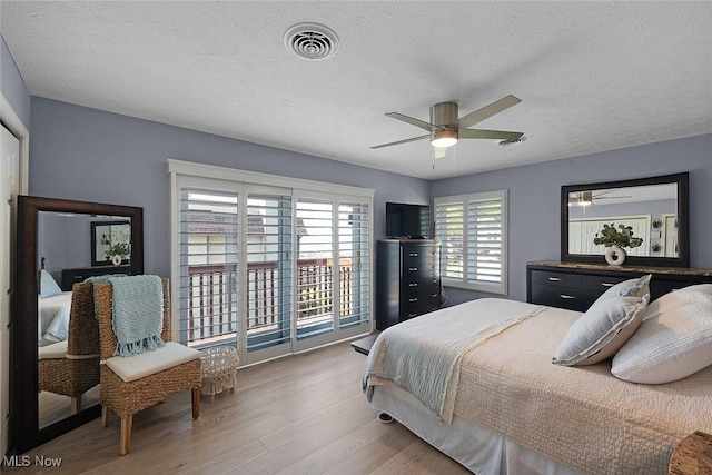 4613 Compass Rose Unit 11, Vermilion, OH 44089 - bedroom featuring light wood-style floors, access to exterior, a textured ceiling, and ceiling fan