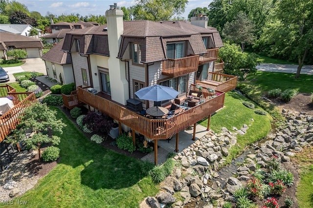 4613 Compass Rose Unit 11, Vermilion, OH 44089 - back of property featuring a balcony, a shingled roof, a chimney, a deck, and a lawn