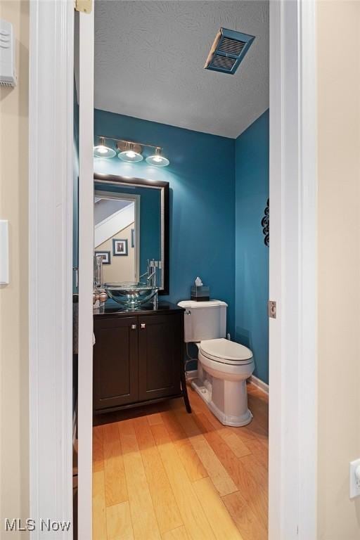 4613 Compass Rose Unit 11, Vermilion, OH 44089 - half bathroom featuring wood finished floors and vanity