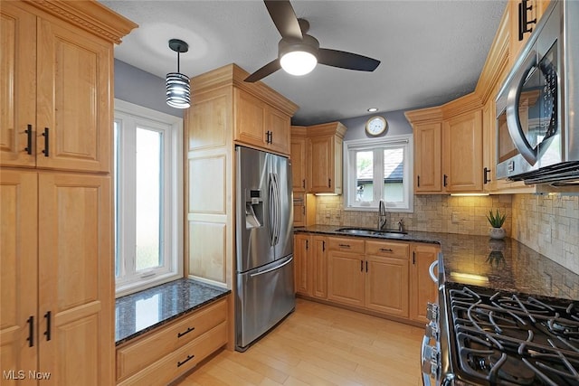4613 Compass Rose Unit 11, Vermilion, OH 44089 - kitchen with appliances with stainless steel finishes, a ceiling fan, tasteful backsplash, light wood finished floors, and dark stone counters