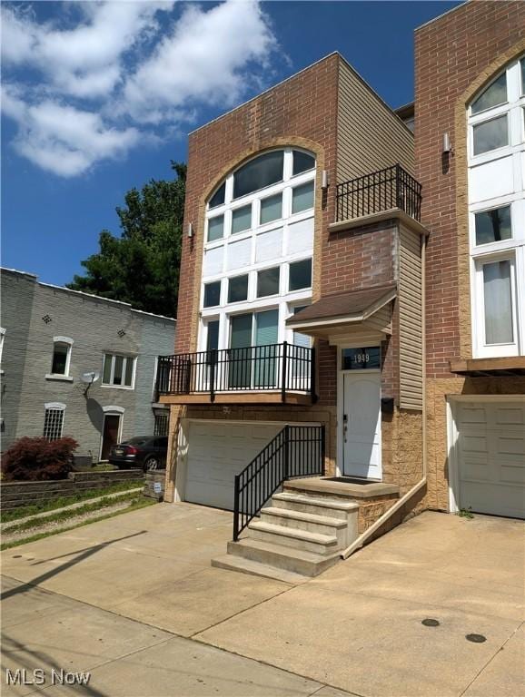 1949 Columbus Rd, Cleveland, OH 44113 - view of front of home with an attached garage, driveway, and a balcony