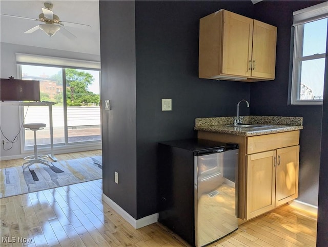 1949 Columbus Rd, Cleveland, OH 44113 - kitchen with light brown cabinetry, light wood-style floors, plenty of natural light, and ceiling fan