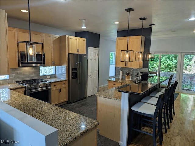 1949 Columbus Rd, Cleveland, OH 44113 - kitchen featuring high end appliances, a peninsula, light stone countertops, decorative backsplash, and recessed lighting