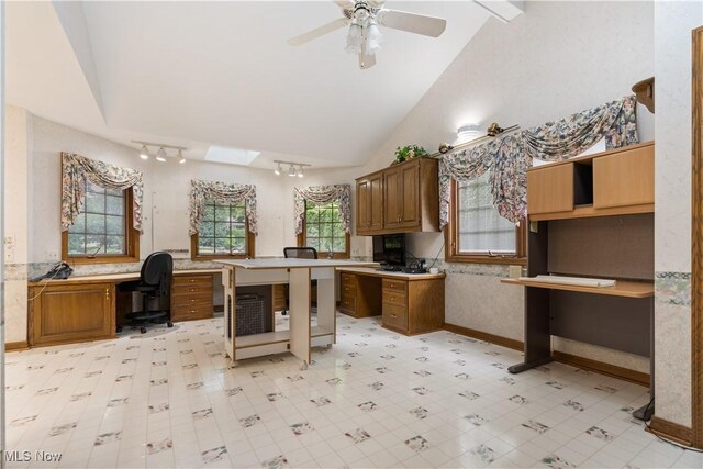 221 Winston Ave NE, North Canton, OH 44720 - kitchen featuring lofted ceiling, built in desk, brown cabinets, a ceiling fan, and light countertops