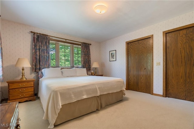 221 Winston Ave NE, North Canton, OH 44720 - bedroom featuring wallpapered walls, carpet, and multiple closets