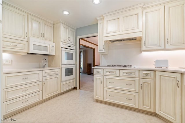 221 Winston Ave NE, North Canton, OH 44720 - kitchen featuring cream cabinets, white appliances, light countertops, light carpet, and recessed lighting