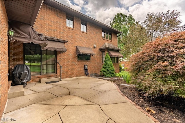 221 Winston Ave NE, North Canton, OH 44720 - back of house featuring brick siding and a patio area