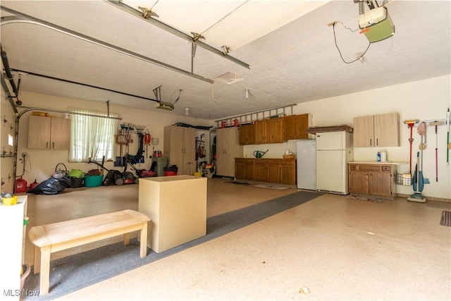 221 Winston Ave NE, North Canton, OH 44720 - garage with freestanding refrigerator, a garage door opener, and fridge