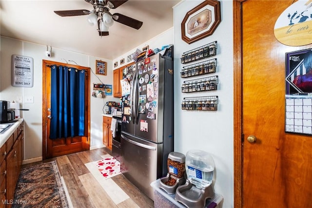 3214 Quentin Dr, Youngstown, OH 44511 - kitchen with freestanding refrigerator, dark wood-style floors, a ceiling fan, brown cabinets, and range