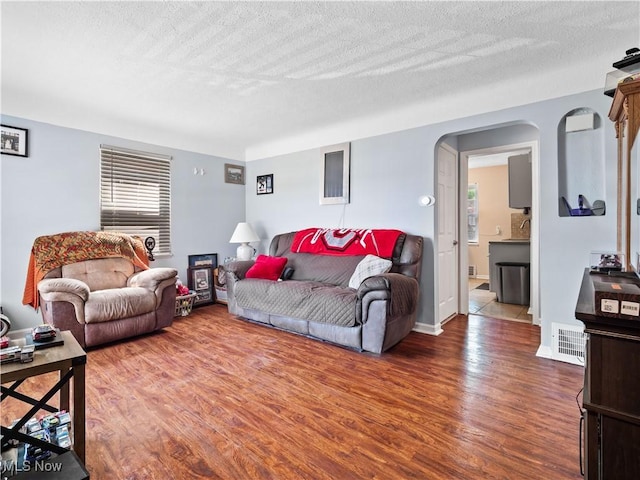4707 Grantwood Dr, Parma, OH 44134 - living room featuring wood finished floors, a textured ceiling, and arched walkways