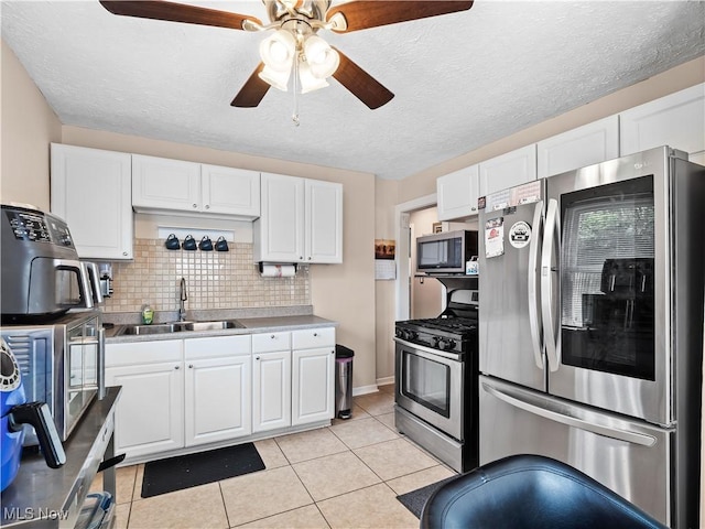 4707 Grantwood Dr, Parma, OH 44134 - kitchen featuring stainless steel appliances, ceiling fan, white cabinets, and a textured ceiling