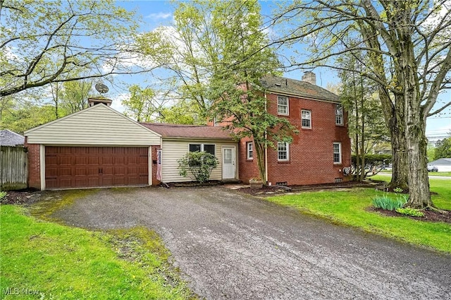 7219 N Lima Rd, Poland, OH 44514 - view of front of property featuring a chimney, brick siding, a garage, asphalt driveway, and a front lawn
